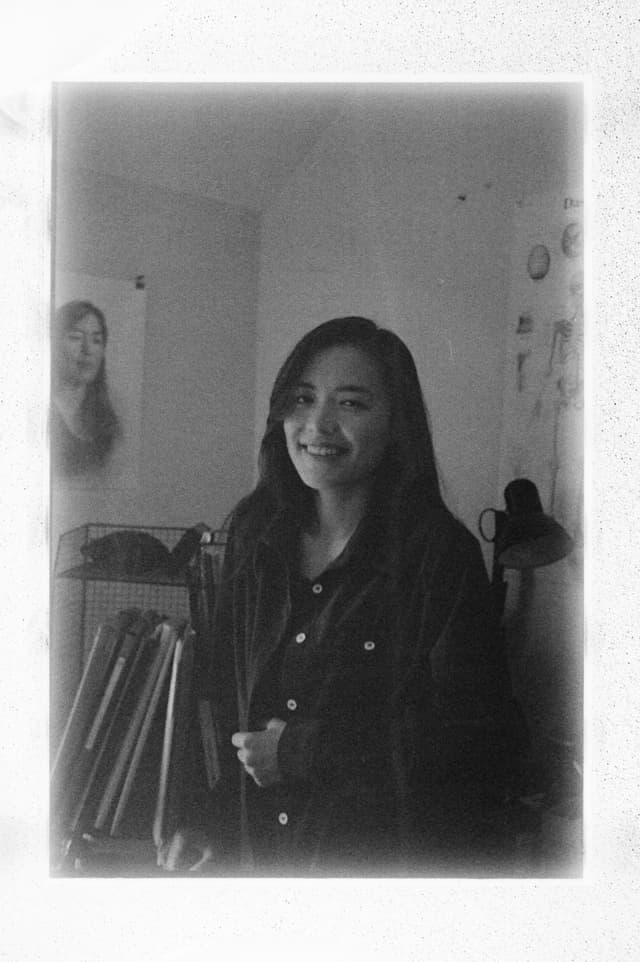 Photo of the artist, smiling, dark hair.