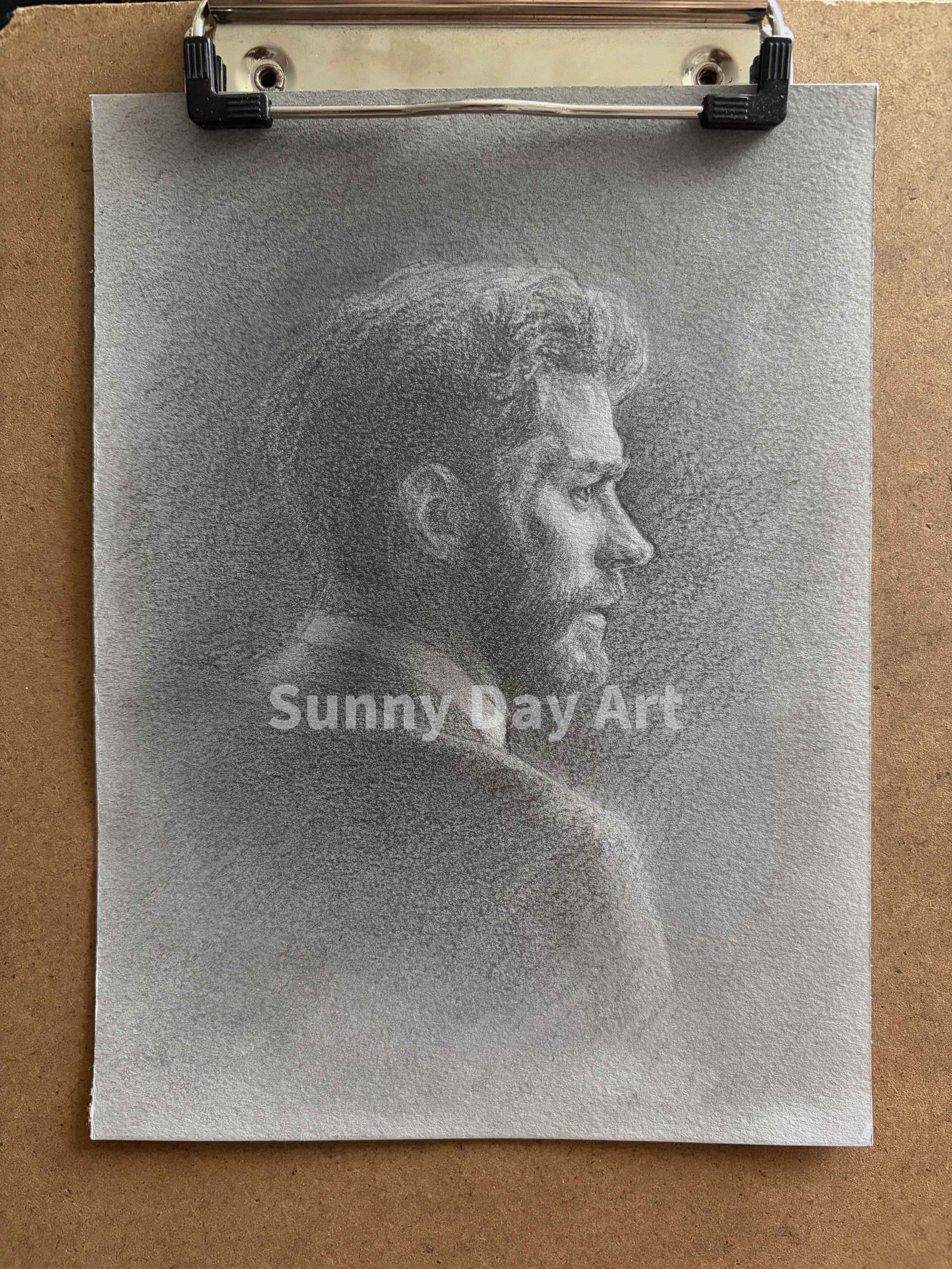 Portrait of a bearded man with neat hair, focused expression, on gray paper.